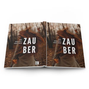 Könnte beinhalten: Ein aufgeschlagenes Buch mit einem Coverbild einer Person mit langem rotem Haar in einem herbstlichen Wald. Der Text auf dem Cover lautet JEDE JAHRESZEIT TRÄGT IHREN ZAU BER in weißen Großbuchstaben. Ein kleiner QR-Code ist unten rechts zu sehen.