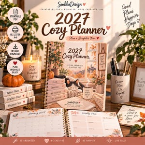 May include: A 2027 spiral-bound planner with a cover illustration of a cat, a coffee mug, and autumn foliage. The cover text reads 2027 Cozy Planner, A More Organized A Happier You. The open planner displays a January 2027 calendar and weekly plan pages.
