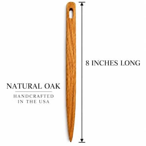 May include: A natural oak wooden tool with a pointed tip and a rectangular hole at the top. The object is 8 inches long, as indicated by the text and measurement line next to it. The text reads NATURAL OAK HANDCRAFTED IN THE USA and 8 INCHES LONG.