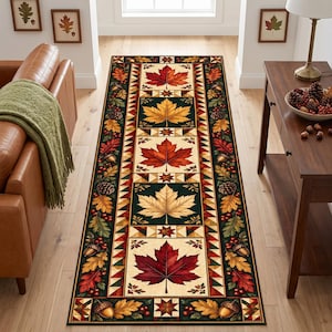 May include: A rectangular area rug featuring a central column of alternating square panels with large maple leaves in shades of red, orange, and yellow. The border displays a pattern of acorns, pinecones, and oak leaves on a dark green background.