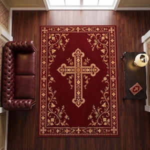 Puede incluir: Una alfombra rectangular con un fondo rojo intenso y un gran motivo de cruz dorada en el centro. El diseño incluye intrincados adornos florales dorados en las esquinas y un borde decorativo con pequeños símbolos de cruces y flores de lis.