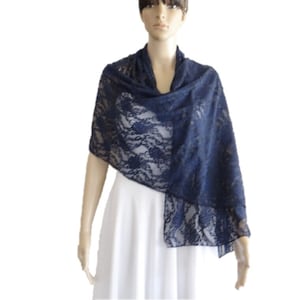 Peut inclure: Un châle en dentelle bleu marine avec un motif floral. Le châle est drapé sur une robe blanche.