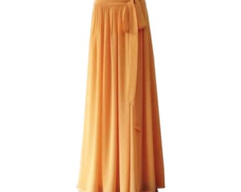 Puede incluir: Una falda maxi larga y fluida de color amarillo mostaza con una faja de tela a juego que se ata a la cintura.