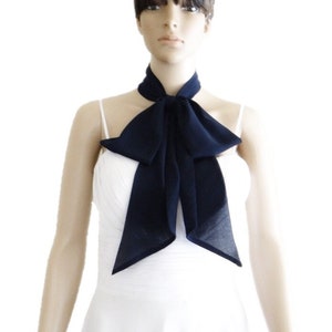 May include: A navy blue chiffon neck scarf tied in a bow. The scarf is worn by a mannequin with short dark hair.