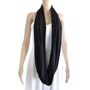 May include: A black infinity scarf made of a soft, stretchy fabric.