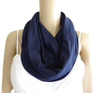 May include: A navy blue infinity scarf made of soft fabric. The scarf is folded and draped around a mannequin's neck.