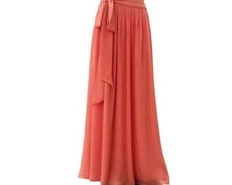 Puede incluir: Una falda larga y fluida de color coral con una cintura ancha y un lazo en la parte delantera.