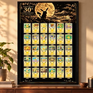 Può includere: Un poster incorniciato con una grafica Pokémon 30th Anniversary 1996-2026 che mostra la sagoma di Pikachu davanti a una luna piena e al Monte Fuji. Sotto, una griglia mostra trenta carte collezionabili Pikachu su sfondo nero.