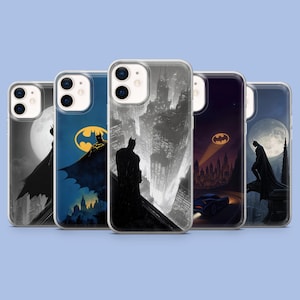 Op de afbeelding: Vijf doorzichtige smartphonehoesjes met diverse grafische illustraties van een figuur met een cape die op daken boven een stad uitkijkt, met ontwerpen inclusief een geel vleermuissymbool, een volle maan en een donker voertuig op een weg.