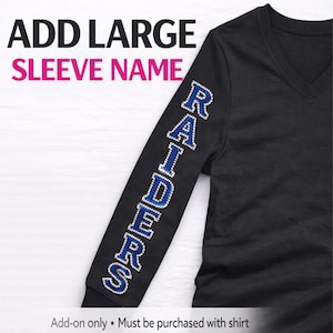 May include: Black long-sleeve V-neck shirt with the word "RAIDERS" in blue and silver rhinestones on the sleeve. The text "ADD LARGE SLEEVE NAME" is at the top of the image.