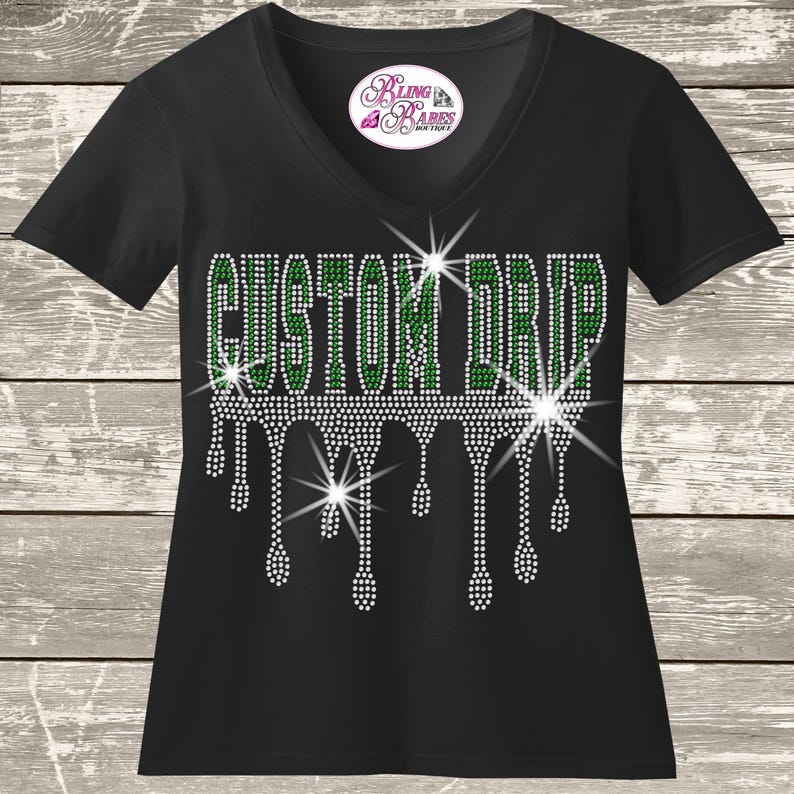 A black t-shirt with a white rhinestone design that spells out "GUSTOM DRIP" with a dripping effect.