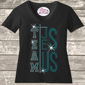A black t-shirt with teal and white rhinestones on it, featuring the text "TEAM JESUS" in a stylized font.