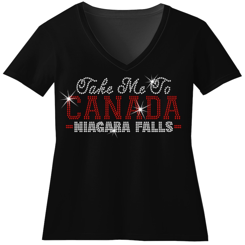 A black t-shirt with the text "Take Me to Canada Niagara Falls" printed on it in red and white.