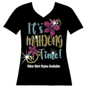 Its mahjong time Thousands of shimmering, sparkling rhinestones makeup this lucky mahjong shirt. The scriptisfun and is in yellow and teal. The flowers and ivy is in hot pink and yellow. Show off your skills with this bright fun mahjong bling shirt