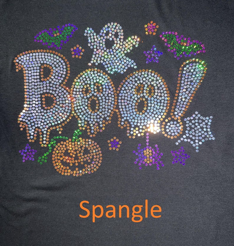 This is an actual picture of our Boo Halloween design featuring fun, spooky-inspired lettering embellished with sparkling spangle for a playful and glamorous look. Perfect for Halloween parties, trick-or-treating, pumpkin patch outings, spooky season celebrations, and anyone who loves cute Halloween fashion with a little sparkle, sass, and bling.