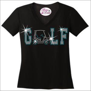 May include: Black v-neck t-shirt featuring rhinestone embellishments spelling out the word 