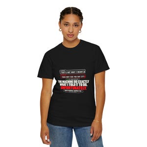 May include: A black short-sleeved t-shirt featuring white and red text that reads: HUMAN: THAT'S NOT WHAT I MEANT. MACHINE: THEN WHY DID YOU SAY IT? NO ERROR DETECTED. THE MACHINE DID EXACTLY WHAT I TOLD IT TO DO. UNFORTUNATELY. BAD SIGNAL SUPPLY CO.