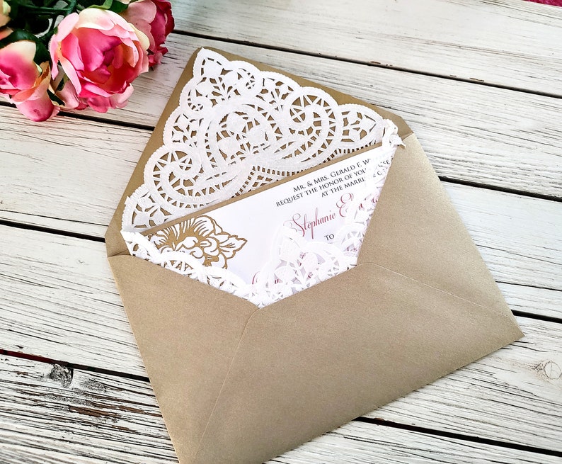 May include: A brown envelope with a white doily and a wedding invitation inside. The invitation is for Stephanie and [unclear text] and requests the honor of your presence at the marriage.