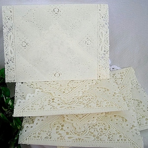 May include: A stack of four white doilies with intricate lace patterns. The doilies are made of delicate paper and have a vintage look.