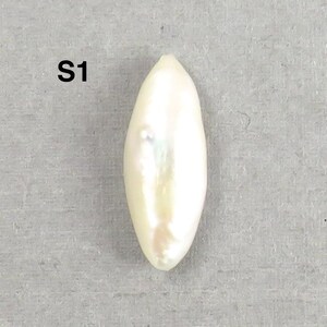 May include: A lustrous, elongated, white pearl with a subtle iridescent sheen. The pearl has a smooth, oval shape and is set against a neutral gray background. The text "S1" is visible in the upper left corner.