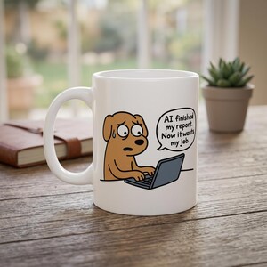 May include: A white ceramic mug featuring a cartoon illustration of a brown dog typing on a laptop. A speech bubble above the dog contains the text: AI finished my report. Now it wants my job. The dog has wide eyes and a bead of sweat on its forehead.