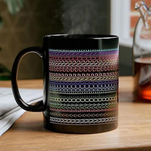 May include: A black ceramic mug featuring a series of horizontal bands decorated with colorful, neon-toned geometric patterns and line designs. The mug has a curved handle on the left side and a smooth, glossy finish across its cylindrical surface.