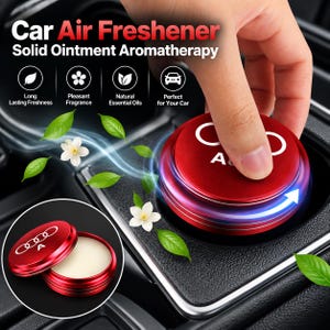 May include: A red circular car air freshener featuring a solid ointment aromatherapy balm. The lid displays the Audi logo and the letter A. The product is shown in a closed state and an open state, revealing the white solid balm inside the container.