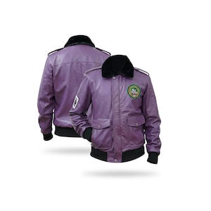 May include: A purple leather bomber jacket featuring a black faux fur collar, black ribbed cuffs and hem, and two front flap pockets. The jacket displays a circular patch with a clown graphic on the left chest and a rectangular patch on the right sleeve.