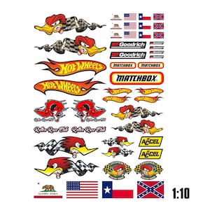 Puede incluir: Una hoja de pegatinas con varios diseños de carreras, incluyendo patos de dibujos animados con banderas a cuadros, logotipos de Hot Wheels y Matchbox, marca BFGoodrich, logotipos de Accel y varias banderas como California, EE. UU., Texas.