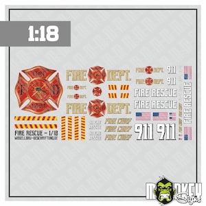 May include: A 1:18 scale decal sheet featuring fire department graphics, including red and gold Maltese cross emblems, yellow and red hazard stripes, American flags, and text reading FIRE DEPT, FIRE RESCUE, FIRE CHIEF, and 911 in various sizes.