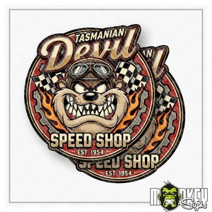 Puede incluir: Una pegatina circular con un dibujo animado del demonio de Tasmania con gafas de aviador, centrado en un marco con forma de engranaje. El diseño incluye llamas naranjas, banderas a cuadros y el texto Tasmanian Devil Speed Shop Est. 1954 en negrita.