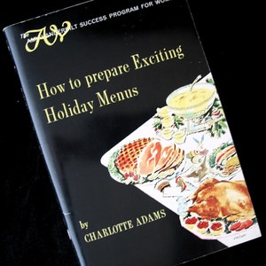 May include: A vintage cookbook titled "How to prepare Exciting Holiday Menus" by Charlotte Adams. The cover is black with gold lettering and a colorful illustration of a holiday meal, including a roasted turkey and ham.