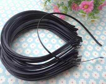 May include: A bulk pack of black metal headbands. The headbands are thin and flexible, and they are stacked on top of each other.