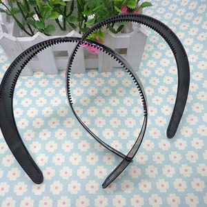 May include: Two black plastic headbands with a textured grip. The headbands are designed to hold hair in place.