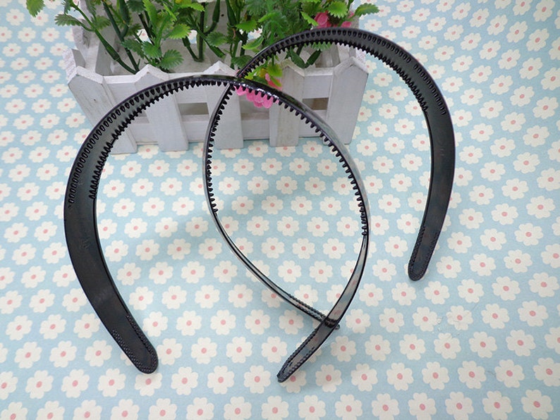 May include: Two black plastic headbands with a textured grip. The headbands are designed to hold hair in place.
