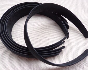 May include: A set of black plastic headbands. The headbands are all the same size and are stacked on top of each other.