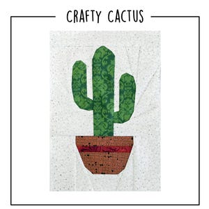 May include: A fabric quilt block featuring the text CRAFTY CACTUS at the top. The design shows a green cactus with a damask pattern in a brown pot with a dark red horizontal stripe, all set against a light gray background with a subtle leaf print.