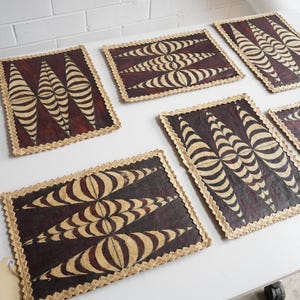 May include: Several rectangular decorative panels featuring a dark brown backdrop and a cream-coloured, striped pattern. The edges are trimmed with a light brown, textured border. They are displayed on a white surface.