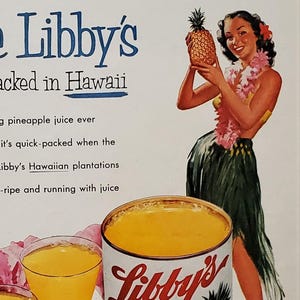 May include: A vintage advertisement for Libby's pineapple juice. The ad features a woman in a hula skirt holding a pineapple and a can of Libby's pineapple juice. The text reads "Libby's Packed in Hawaii" and "The finest pineapple juice ever. It's quick-packed when the pineapple is ripe and running with juice."
