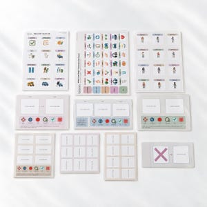 Puede incluir: Una colección de tableros y tarjetas de comunicación visual Bloom con varios iconos, símbolos tipo emoji y espacios en blanco etiquetados como 'Place card here'. El conjunto incluye cuadrículas con ilustraciones de actividades.