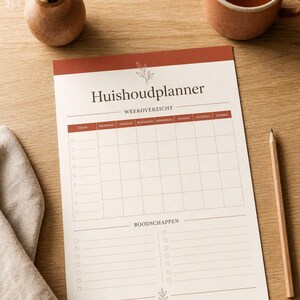 Op de afbeelding: Een huishoudplanner met een crèmekleurige achtergrond en terracotta accenten. De koptekst bevat Huishoudplanner en Weekoverzicht. Het blad heeft een weekoverzicht-rooster, een takenlijst met ronde selectievakjes en een sectie voor boodschappen.