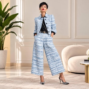 Peut inclure: Une veste en tweed bleu clair et blanc avec un pantalon assorti à jambes larges et coupe courte. La veste présente un col, des manches longues et une fermeture boutonnée sur le devant. Le pantalon a une taille haute et une coupe droite.