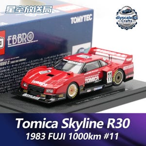 May include: A red Tomica Skyline R30 diecast race car model, number 11, featuring white racing decals, gold mesh wheels, and a black front splitter. The car is displayed on a black base in front of its blue and white branded packaging box.