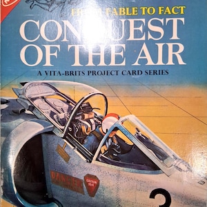 May include: A vintage Nabisco From Fable to Fact Conquest of the Air Vita-Brits project card series featuring a blue and silver fighter jet with a pilot in the cockpit. The card displays the number 3, danger intake warnings, and an ejection seat label.