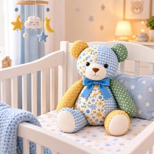 May include: A plush teddy bear featuring a patchwork design with yellow, blue, and green fabrics. The bear has floral and gingham patterns, a solid blue satin ribbon bow around its neck, and black button eyes with a stitched brown nose and mouth.