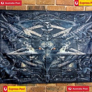 May include: A rectangular black fabric wall hanging featuring a detailed graphic print of a goat head centred within a large pentagram. The design includes intricate filigree patterns, skulls, and glowing orange eyes, with metal grommets in each corner.