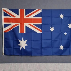 May include: The national flag of Australia features a blue field with the Union Jack in the upper left corner, a large white seven-pointed Commonwealth Star below it, and the five stars of the Southern Cross constellation on the right side.