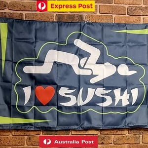 Peut inclure: Un drapeau rectangulaire bleu foncé présentant un graphique blanc de deux silhouettes dans une position sexuelle au-dessus du texte I, un symbole de cœur rouge et le mot SUSHI en blanc. Le design inclut des accents géométriques vert clair.