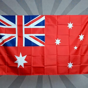 May include: A rectangular red ensign flag featuring a Union Jack in the upper left corner on a red field. The design includes a large seven-pointed white Commonwealth Star in the lower left quadrant and four smaller seven-pointed stars on the right.