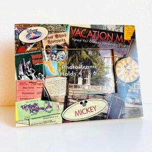 May include: A vintage-style photo frame with a collage of Disney Vacation Club imagery, including Mickey Mouse, the Haunted Mansion, and the Magic Kingdom. The frame is made of wood and has a black finish. It holds a 4x6 inch photo. The text "Vacation Map News for Disney Vacation Club Members" is printed on the frame.